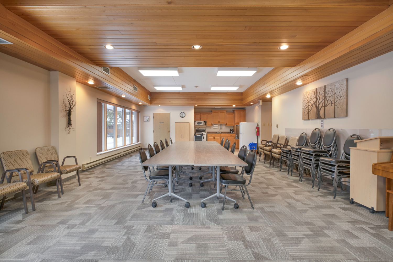 Large community room with a long table, chairs, and additional seating.